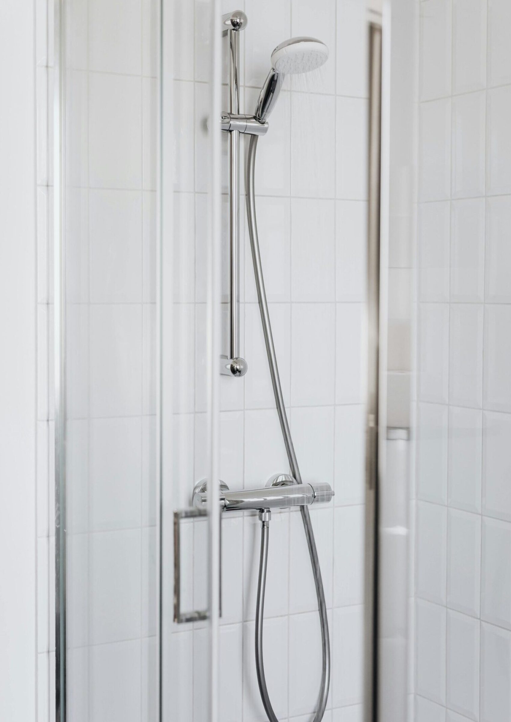 Elegant modern shower with minimalist glass design and stainless steel fixtures.